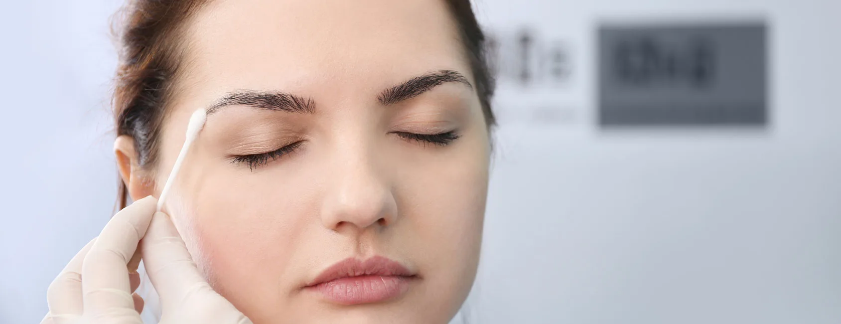 Brow tint being applied with a cotton bud