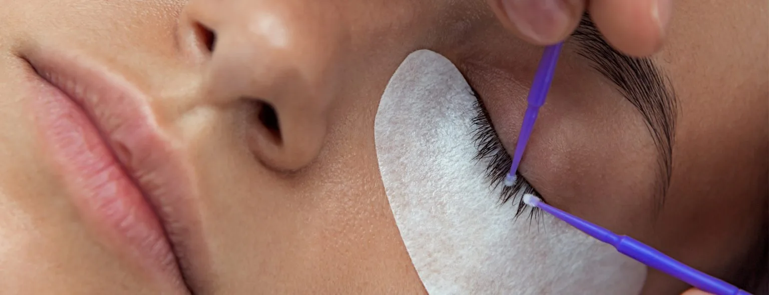 Lash lift treatment showing under-eye pad and applicator brush